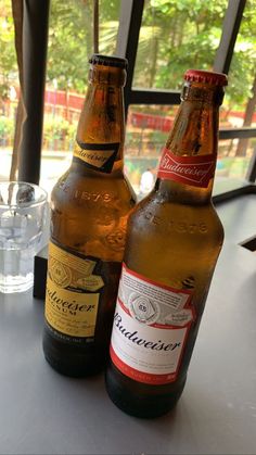 two beer bottles sitting on top of a table