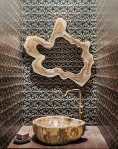 a bowl shaped sink sitting on top of a wooden counter