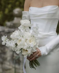 a woman in a white dress holding a bouquet of flowers