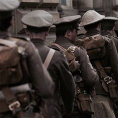 a group of men walking down a street next to each other wearing hats and backpacks