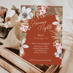 an orange and pink floral birthday party card on top of a wooden box next to flowers