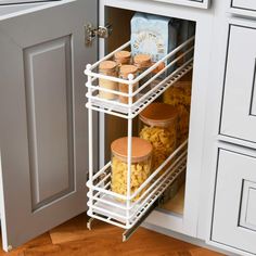 an open cabinet in a kitchen filled with food