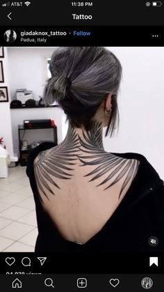 the back of a woman's neck is shown with tattoos on her chest and shoulders