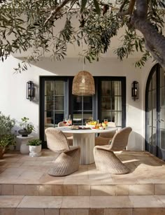 an outdoor dining area with wicker chairs and table