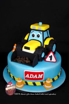 a blue and yellow cake with a tractor on it's side, in the shape of a car