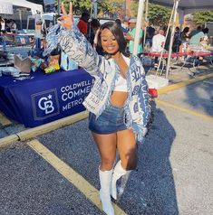 a woman in short denim shorts and white boots