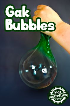 a hand holding a green glass bubble with the words gak bubbles in front of it