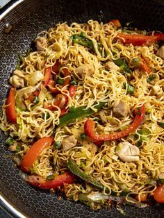 a pan filled with noodles and vegetables on top of a stove