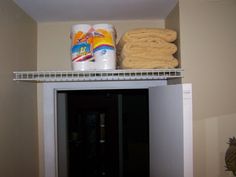 a shelf filled with lots of food next to a can of milk and two stacks of towels