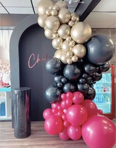 balloons are stacked on top of each other in front of a black and white arch