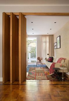 a living room filled with furniture and wooden floors next to a doorway that leads to a patio