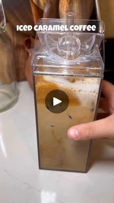 a person is pressing the button on an iced caramel coffee