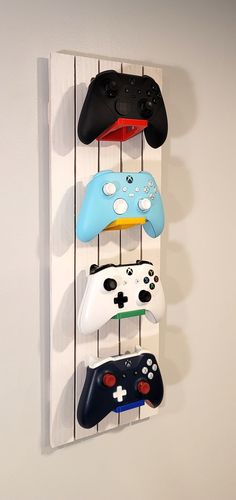 four game controllers are hanging on the wall