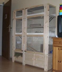 a large wooden cage with two small cages in it's front and back sides