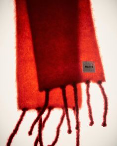 three pieces of red wool with the word omme written on them