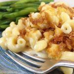 a plate topped with macaroni and cheese next to asparagus