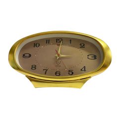 a gold clock with numbers on the face is shown in front of a white background