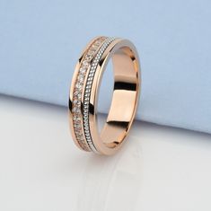 a wedding ring with three rows of diamonds on top of it, sitting on a white surface