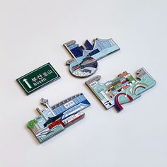 three pins depicting different locations on a white surface