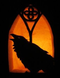 a black bird sitting on top of a window sill in front of a light