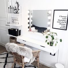 a white vanity with lights on and a chair in front of it, next to a mirror