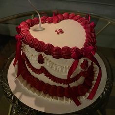 a heart shaped cake with red ribbons on it