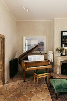 a living room with a piano and fireplace