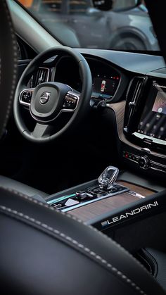 the interior of a car with an entertainment system and steering wheel controls in front of it