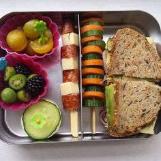 a lunch box with sandwiches, fruit and veggies