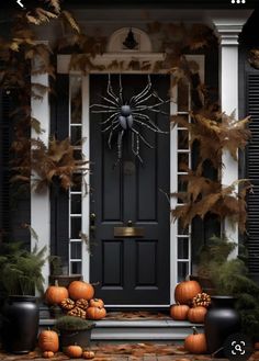 the front door is decorated for halloween with pumpkins and spider web decorations on it