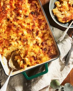 a casserole dish on a table with two bowls of macaroni and cheese