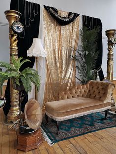 a living room filled with lots of furniture next to a gold drape covered wall