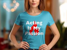 "Showcase your love for the performing arts with our statement t-shirt that reads \"Acting Is My Passion\" set against a striking red flame graphic. This bold, black tee is perfect for actors, theater enthusiasts, and those who live for the stage. Whether you're attending a rehearsal, heading to a casual outing, or gifting it to a passionate actor in your life, this shirt is designed to turn heads and convey your passion for acting. Its comfortable fabric makes it ideal for daily wear or as a conversation starter at your next theater gathering. Product Features: Fabrication: 100% Airlume combed and ring-spun cotton, 32 single 4.2 oz. (Ash - 99% Airlume combed and ring-spun cotton, 1% poly) Seams: Side-seamed Fit: Retail Fit Sizing: Unisex Sizing Label: Tear away label" Fitted Red Slogan T-shirt, Red Fitted T-shirt With Band Merch, White Typography, Flame Design, Shirt Art, Statement Tees, My Passion, Music Is, Black Design