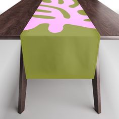 the table is covered with a pink and green design on it's edge,