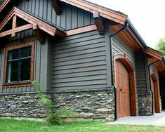 a gray house with wood trim and windows