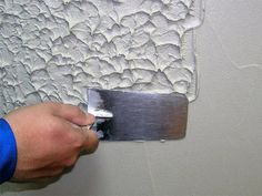 a person using a knife to paint a wall