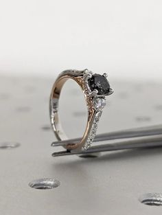 a close up of a ring on top of a silver surface with drops of water