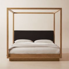 a bed with a black headboard and white sheets