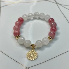 Strawberry quartz round bracelet with white quartz faceted stones and gold plated charm. Gemstone sizes 10mm. Handmade with durable stretch elastic string.  Size 7.5 inches, approximate. It is believed that the Strawberry quartz stone promotes life & growth along with love & affection. It enlightens your Heart Chakra and is the stone of Joy. CARE INSTRUCTIONS:  Take it off before bathing, exercising, swimming. Keep your bracelet in a dry place.  Don't wear it in a wet environment such as a pool White Rose Quartz Bracelets With 8mm Beads, White Rose Quartz Crystal Bracelet As A Gift, White Rose Quartz Beaded Bracelets With 8mm Beads, White Rose Quartz Beaded Bracelets With Round Beads, White Rose Quartz Beaded Bracelet With 8mm Beads, White Rose Quartz Bracelets With Round Beads, White Rose Quartz Beaded Bracelets, White Rose Quartz Crystal Bracelet With Gemstone Beads, White Rose Quartz Crystal Bracelet With Round Beads