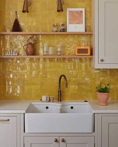 a kitchen with yellow walls and white cabinets