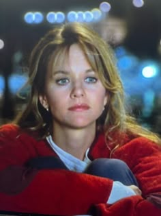 a woman with blue eyes is sitting in front of a laptop computer and looking at the camera