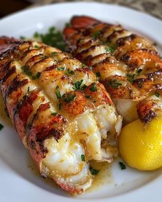 two cooked lobsters on a plate with lemon and parsley garnishes