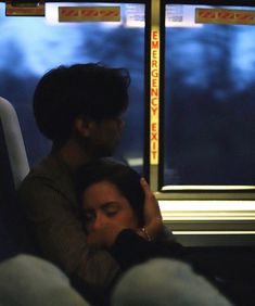 two people sitting on a bus with their arms around each other