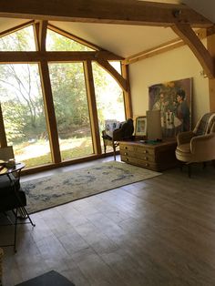 a living room filled with furniture and lots of glass doors that look out onto the woods