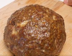 a ball of meat sitting on top of a wooden cutting board