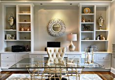 a glass table with chairs in front of white bookcases and built - in bookshelves