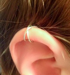 a close up of a person's ear with two thin silver rings on it