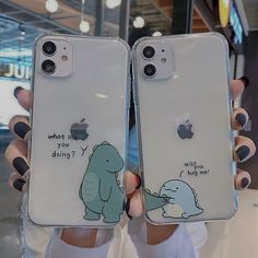 two people holding up their iphone cases with cartoon drawings on them