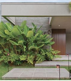 the house is surrounded by greenery and stone steps that lead up to the front door