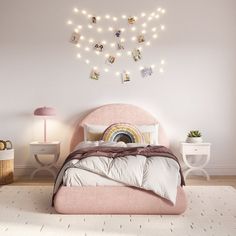 a bedroom with a pink bed and string lights above the headboard is decorated with photos